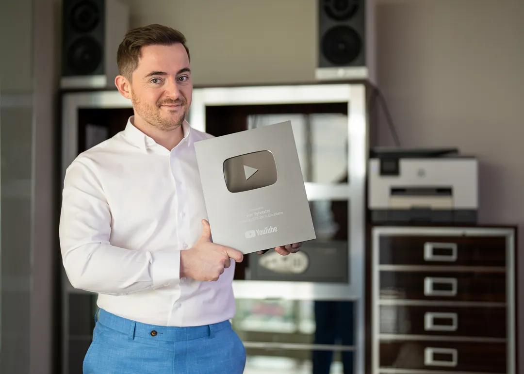 Leon holding the YouTube 100,000 subscribers plaque